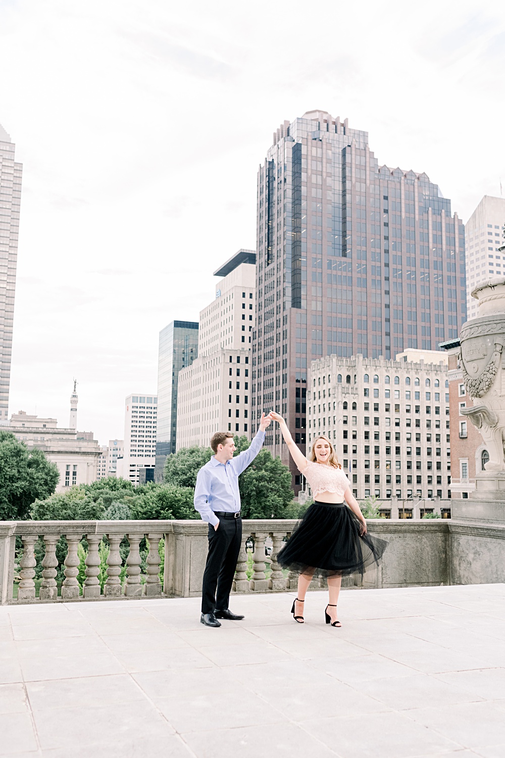 Couple shares a dance on a terrace with the Indianapolis skyline behind them.
