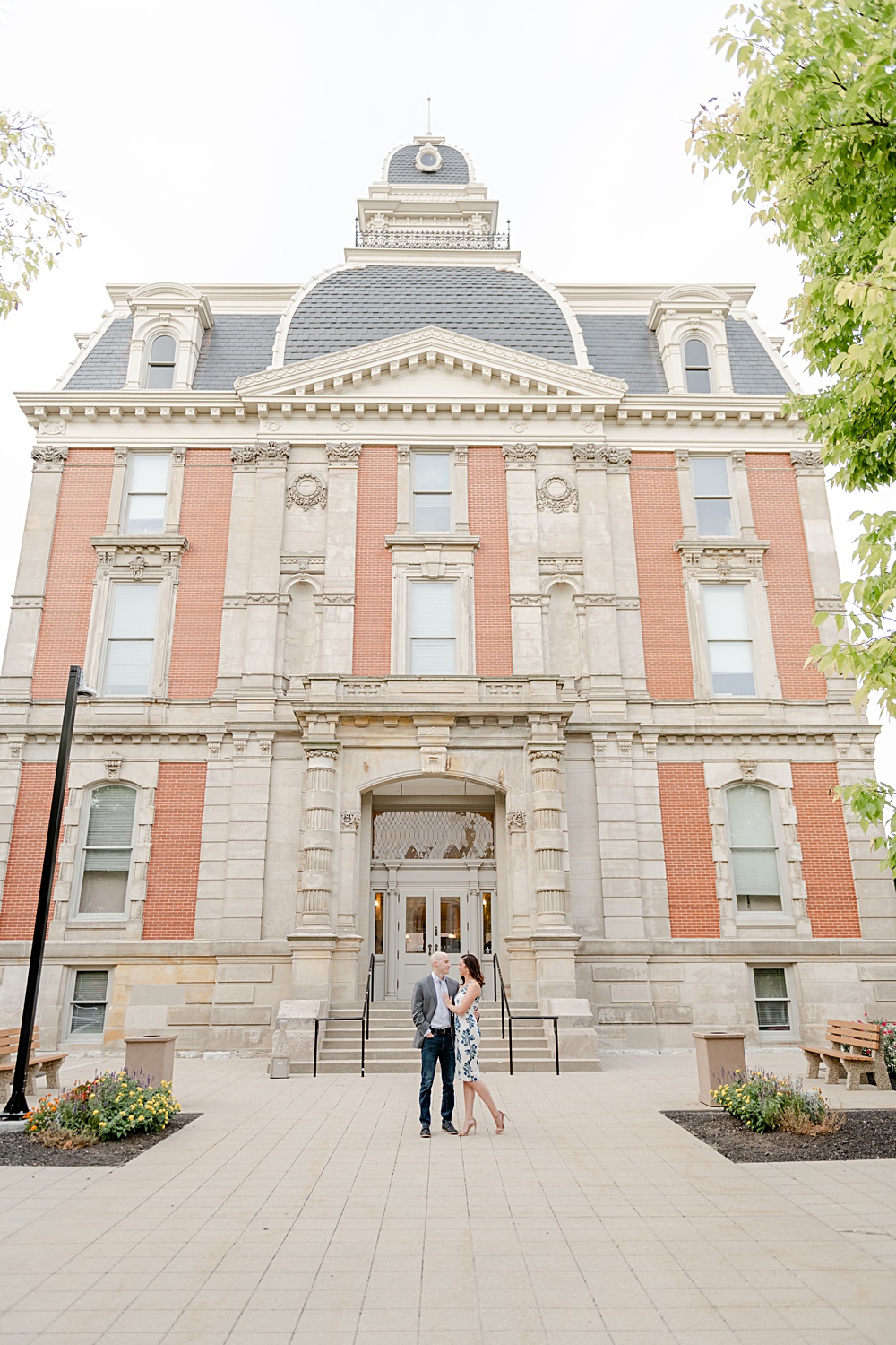 Couple sharing a romantic kiss in front of historic building.