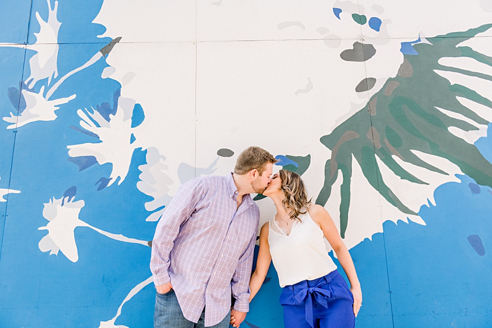 Couple shares a kiss in front of a blue and white mural in Fountain Square, a neighborhood on the southeast side of Indianapolis, Indiana.