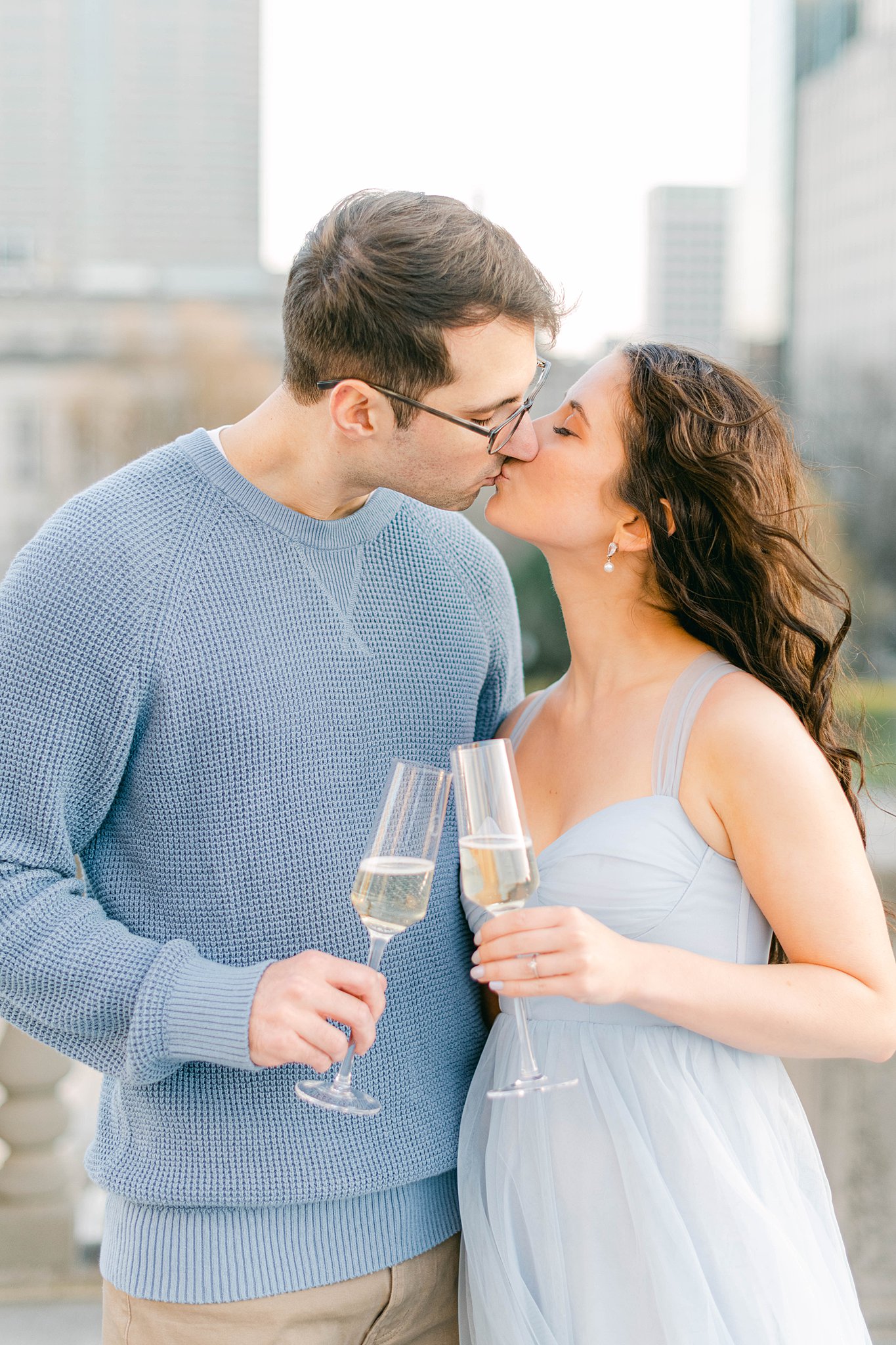 A couple share a champagne toast in Indianapolis at the war memorial during their Spring Engagement Session in Indianapolis