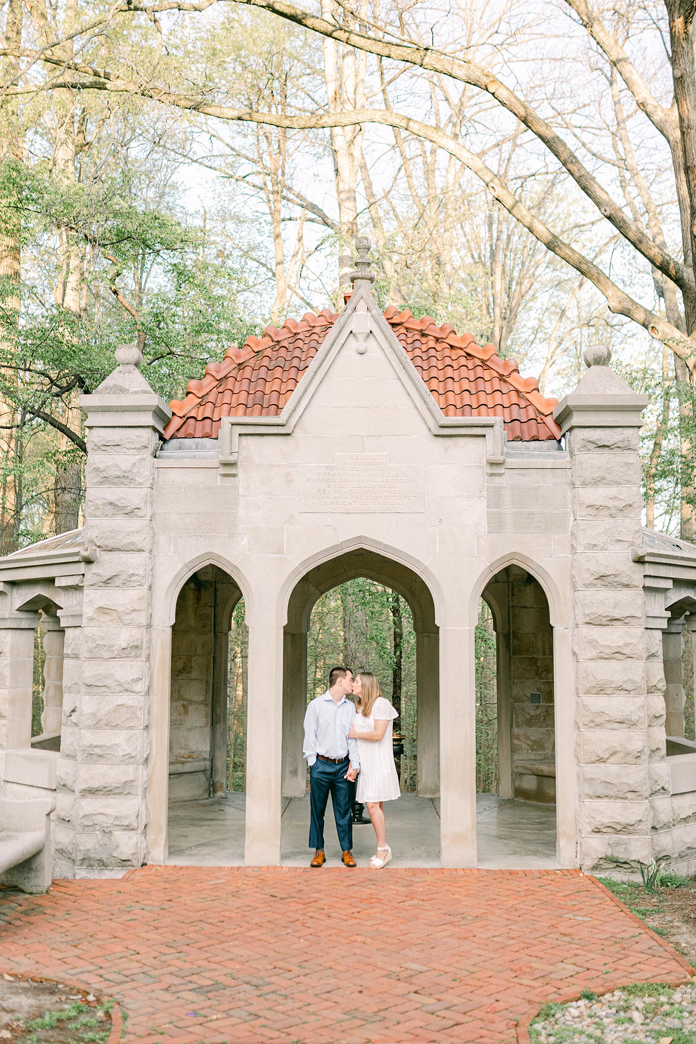 Couple shares a kiss at the well on the Indiana University Campus during their spring Indiana University campus in Bloomington, Indiana.