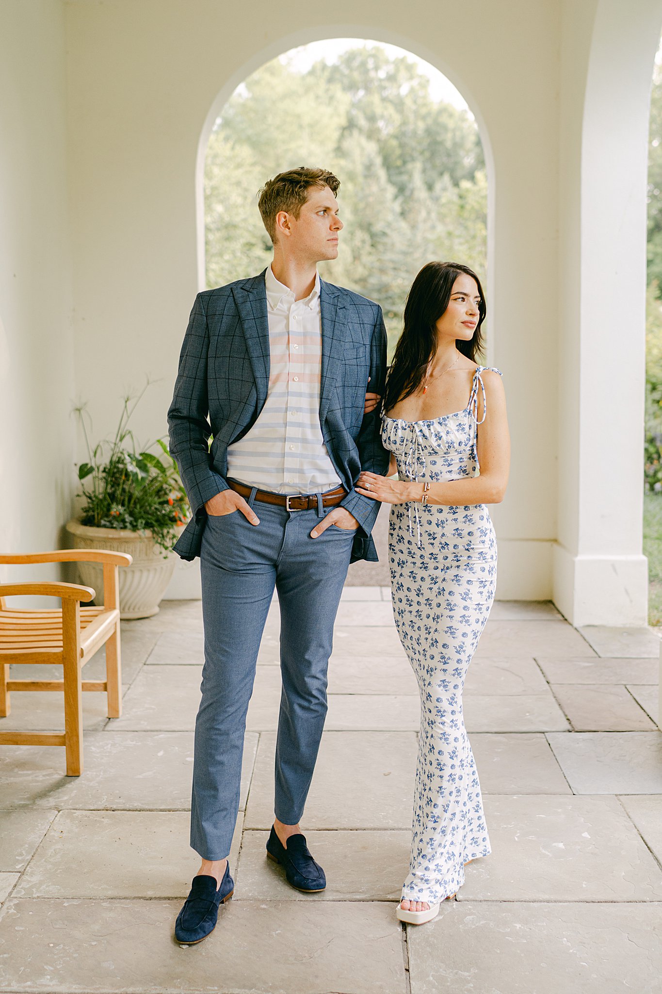 Mara and Sean stand under the elegant white arches of the Lilly Mansion at Newfields