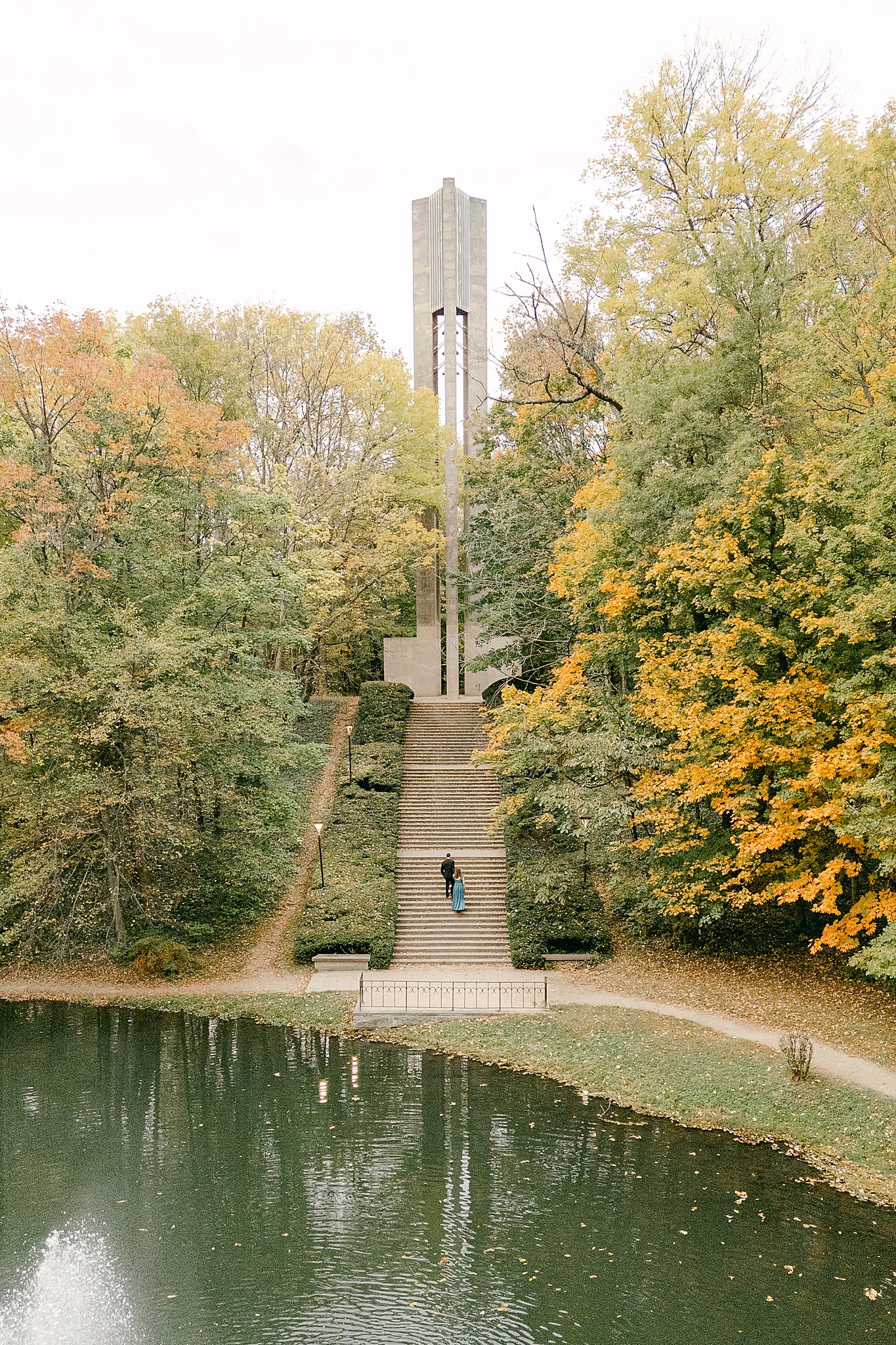 Couple climbing to the top of the bell tower at Butler University Holcomb Gardens while taking engagement photos