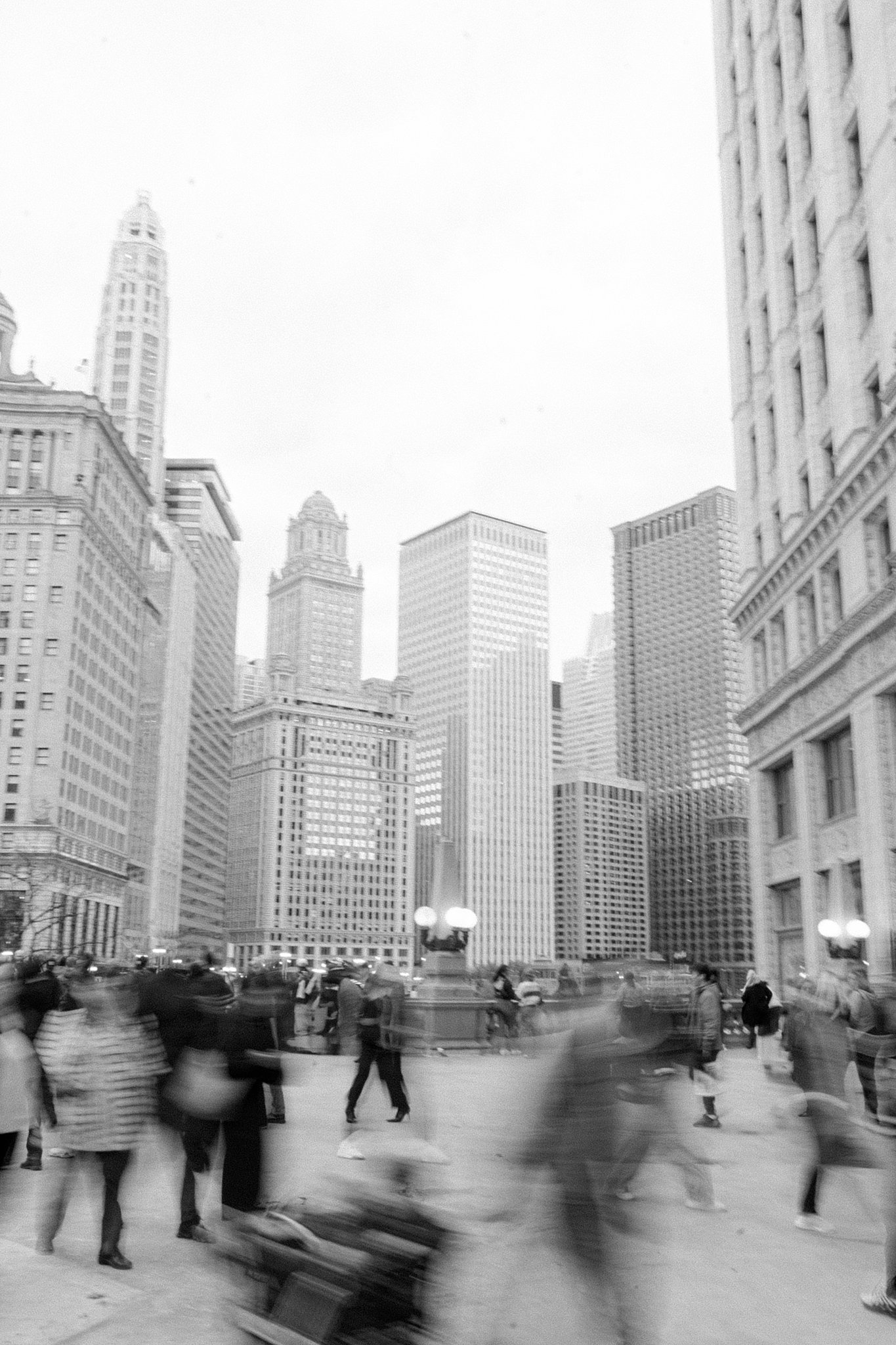 A moment frozen in time - a black and white image of people walking by the Wrigley Building in Chicago with some of the subjects blurring from motion