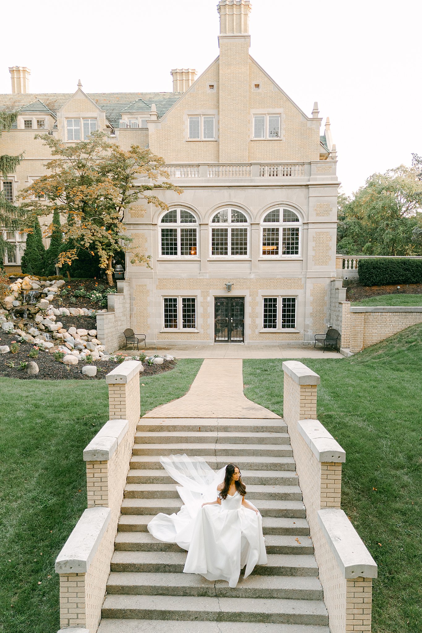 Drone image of a bride walking down an outdoor staircase at Laurel Hall in Indianapolis