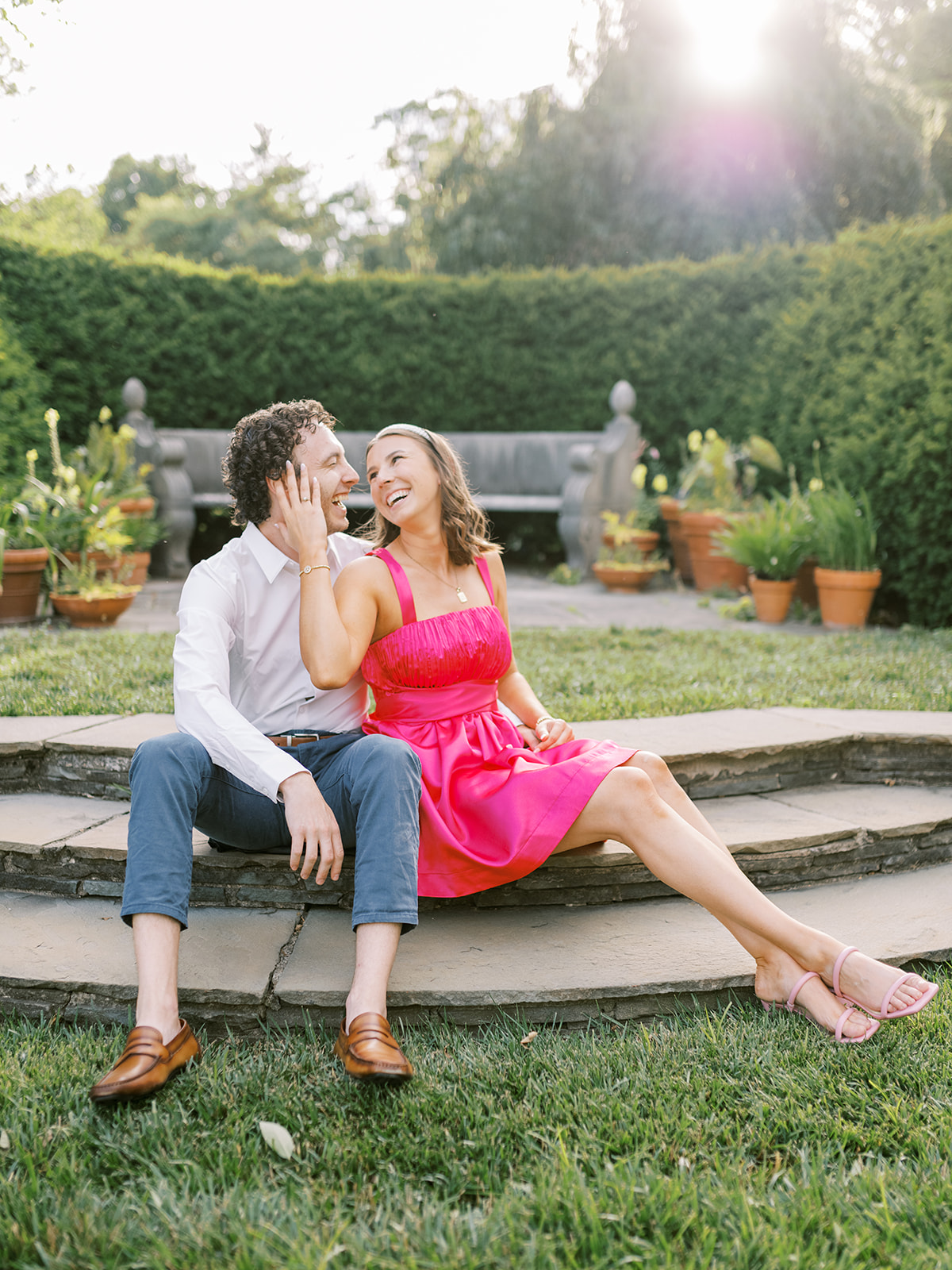 Couple laughing together on step at Newfields during engagement session